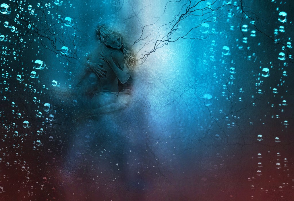 A man and a woman embrace under water